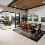 Custom indoor/outdoor fusion with outdoor fan, outdoor kitchen and multiple seating areas.