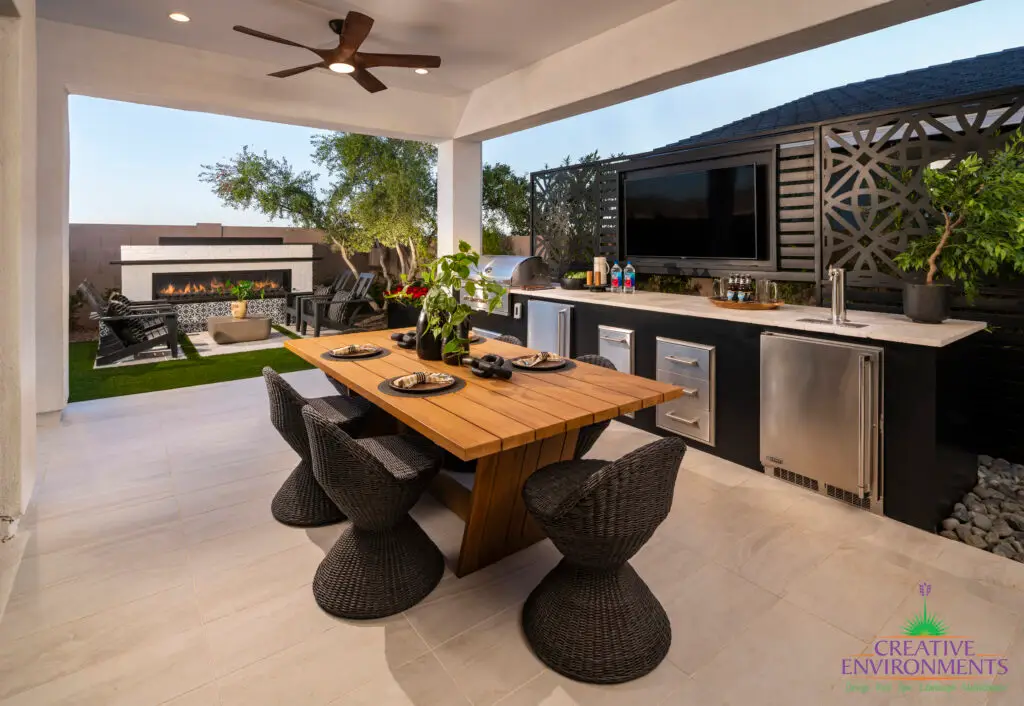 Custom backyard design with metal statement piece, outdoor bar and recessed lighting.