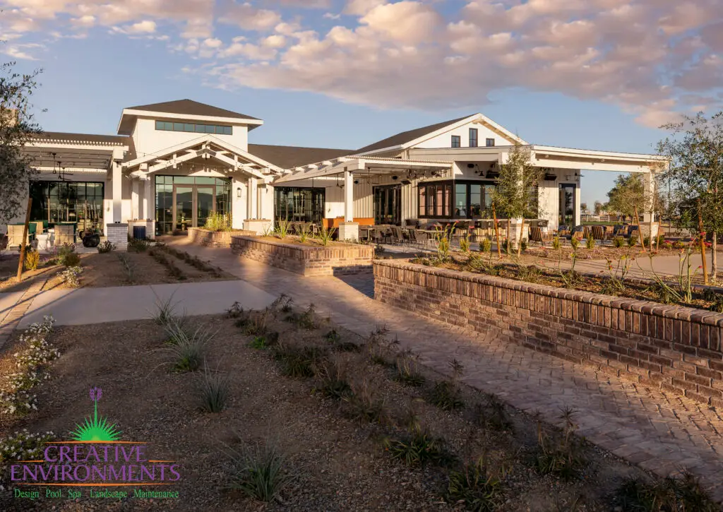 Custom community amenities with clubhouse, brick paver walkway and organized planting.