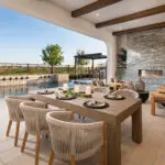 Custom backyard design with marble fireplace, multiple seating areas and Spanish style pool.