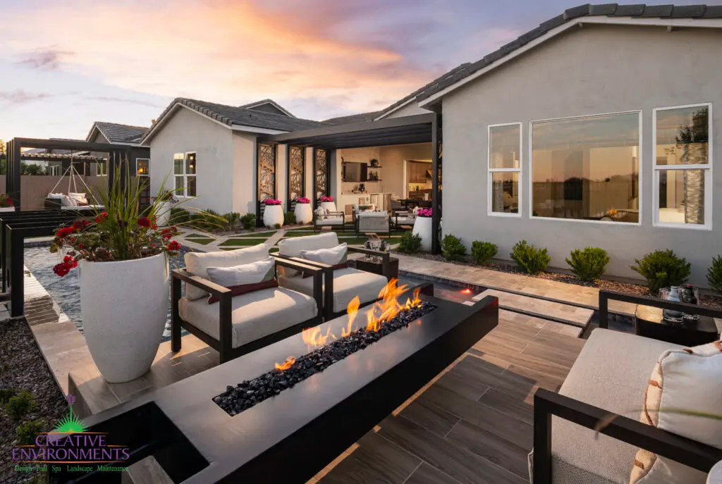 Custom backyard design with cantilevered fire table, large planters and large metal cutouts.