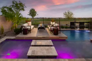 Custom backyard design with Jesus steps, floating fire table and metal scupper water feature into pool.