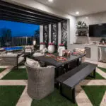 Custom backyard design with artificial turf pattern, outdoor TV and outdoor shelving.