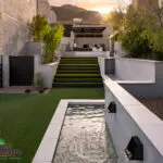 Custom backyard design with natural stone water feature and step lighting