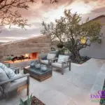 Custom backyard design with angled fireplace and outdoor seating area.
