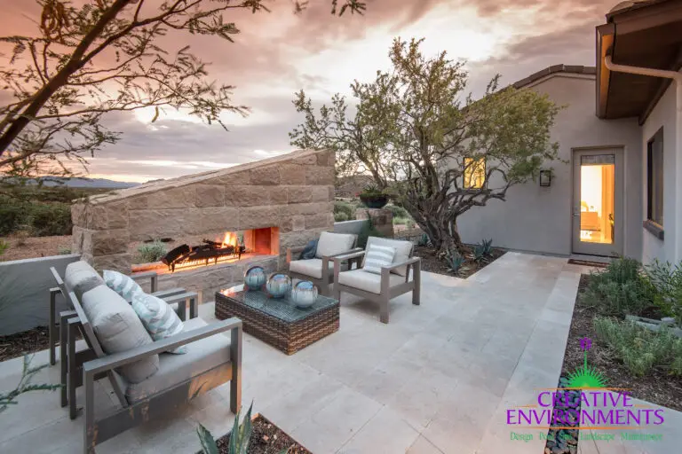 Custom backyard design with angled fireplace and outdoor seating area.