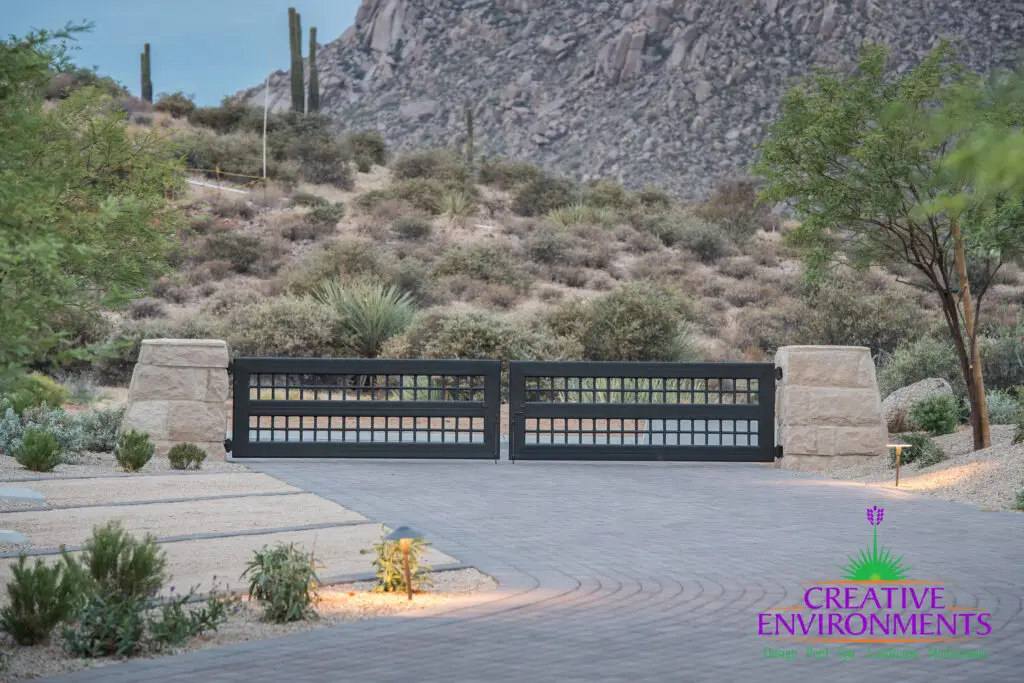 Custom metal entry gate with desert plants and natural views.