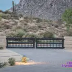 Custom metal entry gate with desert plants and natural views.