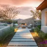 Custom backyard design with angled fireplace, natural stone steps and desert plants with up lighting.