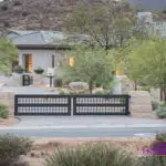 Custom front yard design with metal entry gate with wok planters and desert plants.