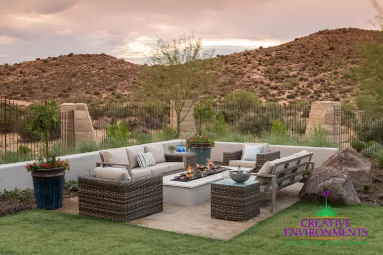 Custom backyard design with large potted plants, metal gate and fire pit.