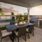 Custom backyard design with outdoor kitchen, raised spa and outdoor dining area.