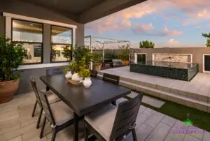 Custom backyard design with outdoor dining area and string lights.