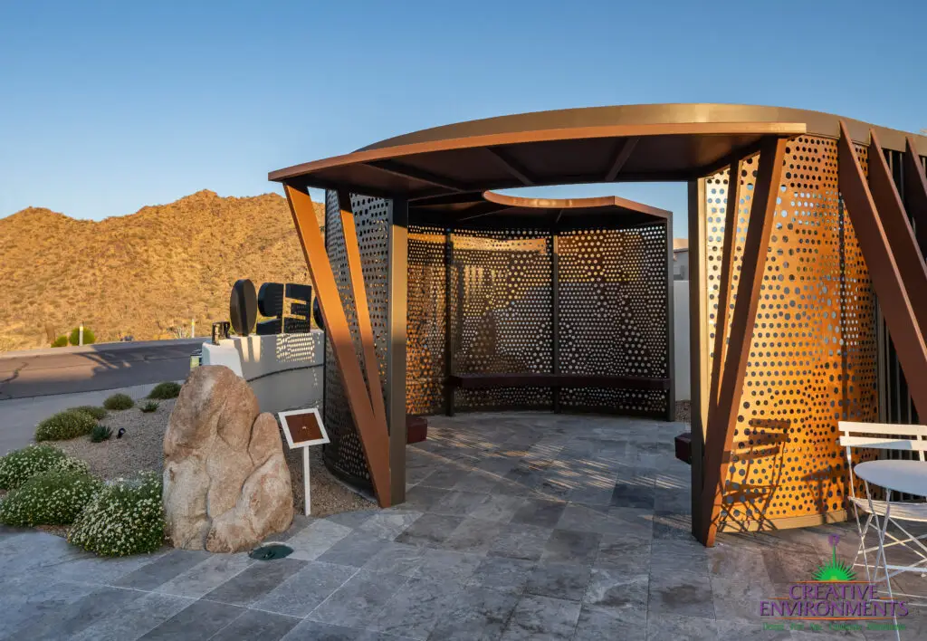 Custom community entrance with unique shade structure, organized planting and metal statement piece.