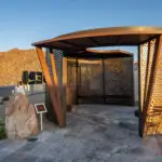 Custom community entrance with unique shade structure, organized planting and metal statement piece.