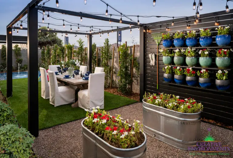 Backyard design with galvanized metal planters, potted plant wall and string lights