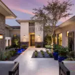 Custom front yard design with uplighting, metal trellis and water bubbler water feature.