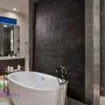 Custom backyard design with black water wall, outdoor tub and indoor/outdoor design fusion.