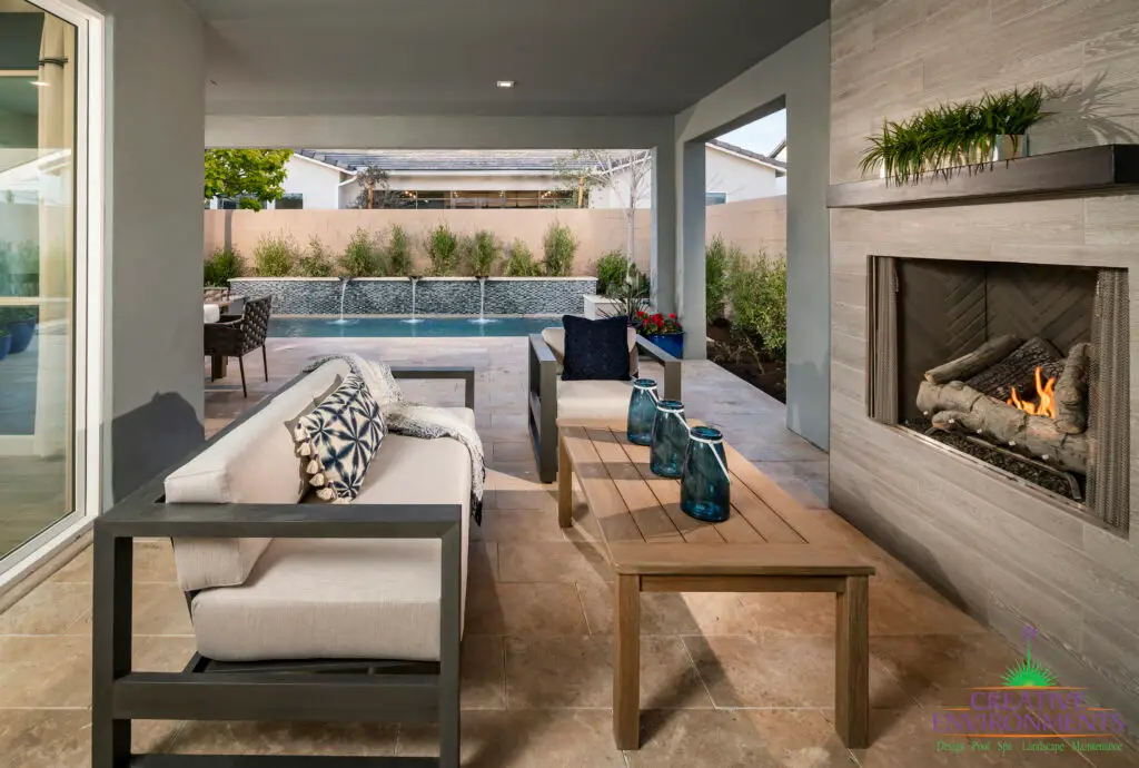 Custom backyard design with deco-tile pool wall, fireplace and organized planting.