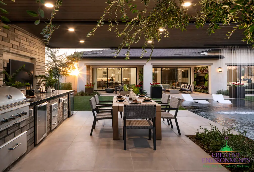 Custom backyard design with outdoor kitchen, pool with baja step and multiple seating areas.