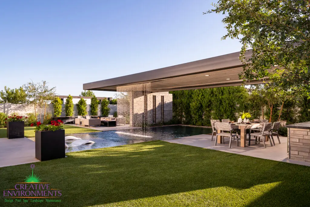 Custom backyard design with large metal planters, metal shade structure and multiple seating areas.