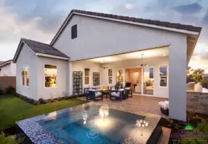 Custom backyard design with metal trellis, blue spa and outdoor dining area.