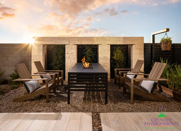Custom backyard design with hanging plants, fire table and outdoor seating area.