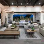 Custom indoor/outdoor design fusion with similar marble fireplaces, multiple seating areas and privacy hedges.
