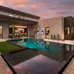 Custom backyard design with zero-edge pool, baja step and outdoor bar seating.