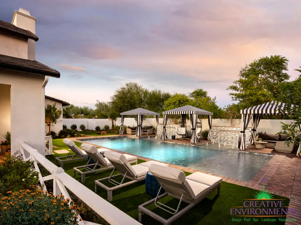 Custom backyard design with cabanas, water bubblers and traditional pool.