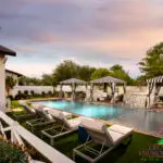 Custom backyard design with cabanas, water bubblers and traditional pool.
