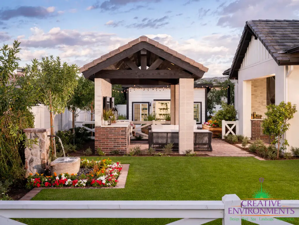 Custom backyard design with real grass, water fountain and shade structure.
