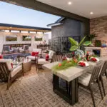 Custom backyard design with multiple seating areas, outdoor kitchen and cantilevered shade structure with multiple outdoor TVs.
