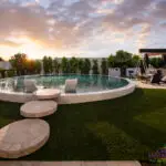 Custom backyard design with circular steps into circular pool and artificial grass decking.