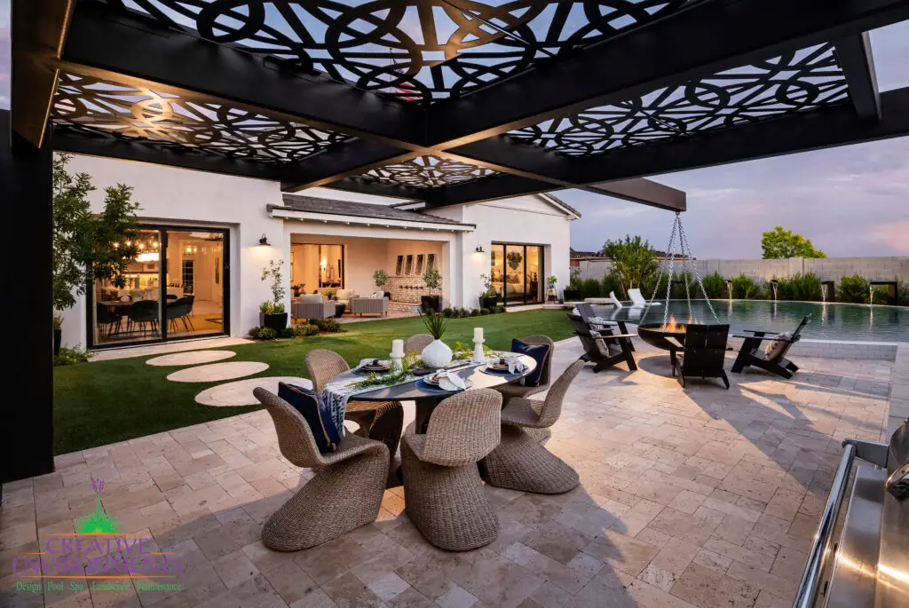 Customized backyard design with patterned metal shade structure, multiple seating areas and cantilevered wok fire pit.