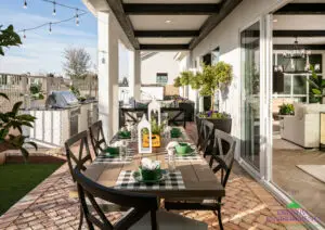 Custom backyard design with multiple seating areas, metal planters and string lights.