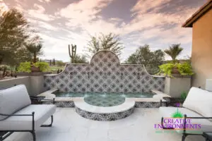 Custom backyard design with deco-tile water feature, Spanish design style and outdoor seating area.