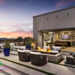 Custom backyard with seamless indoor/outdoor design, multiple seating areas and fire table.