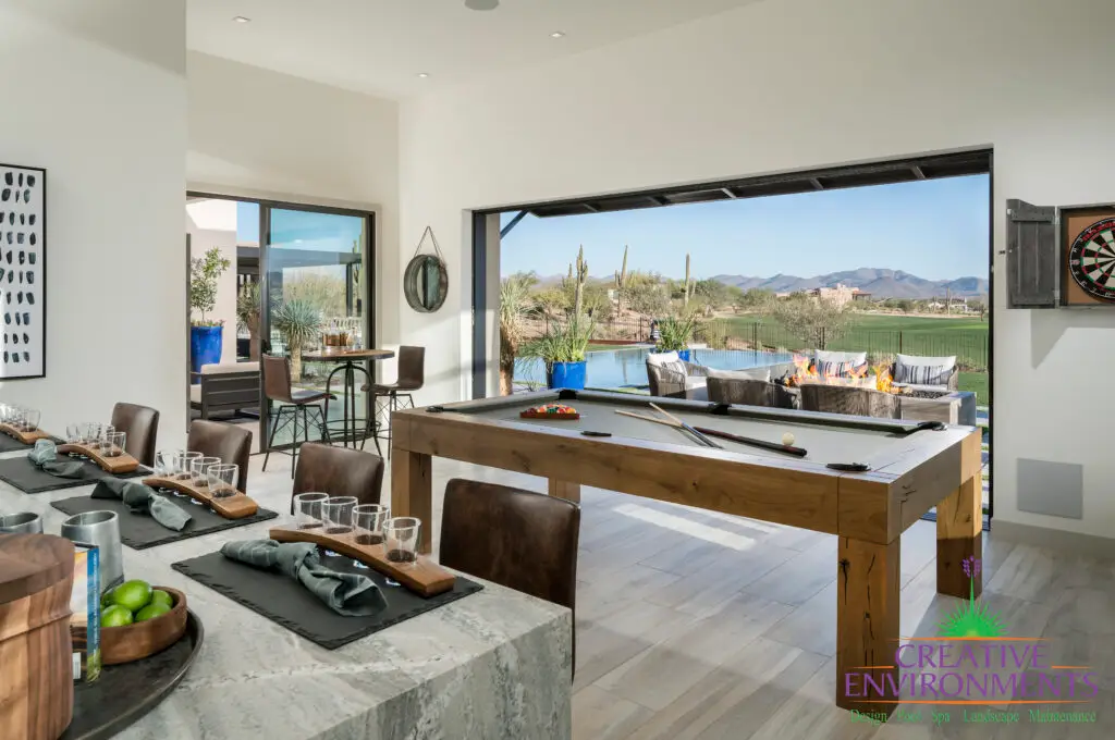 Custom indoor/outdoor design fusion with outdoor entertainment area, pool table and multiple seating areas.
