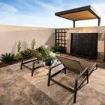 Custom backyard design with cantilevered outdoor shower, black water wall and metal trellises.