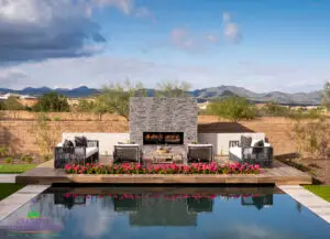 Custom backyard design with fireplace, raised seating area and zero-edge pool.