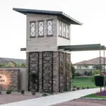 Custom community entrance with entryway sign, metal trellis and real grass.