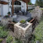 Custom backyard design with brick columns, wok planters and brick fireplace.