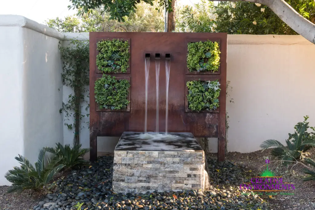 Custom backyard design with succulent living wall, metal scupper water feature and organized planting.