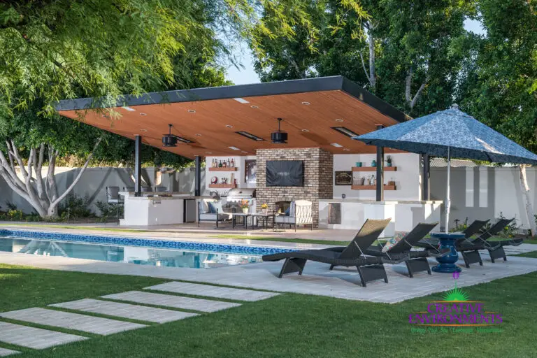 Custom backyard design with real grass, angled shade structure and outdoor entertainment area.