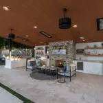 Custom backyard design with outdoor shelving, recessed lighting and outdoor kitchen.