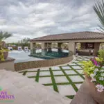 Custom backyard design with artificial turf pattern, large planters and curved, zero-edge pool.