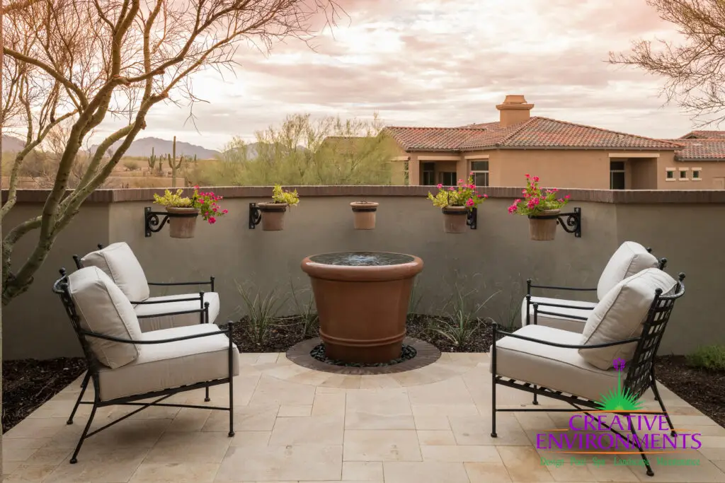 Custom backyard design with water feature, floating planters and outdoor seating area.