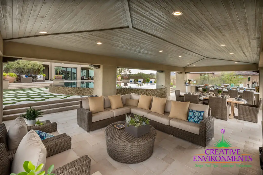 Custom backyard design with zero-edge pool, shade structure and multiple seating areas.