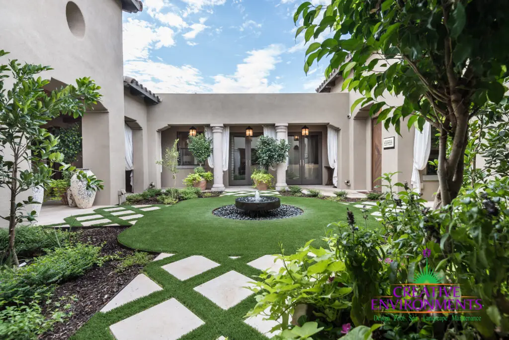 Custom courtyard design with water fountain, large planters and artificial turf pattern.
